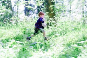 boy running through trees
