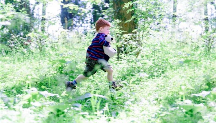 boy running through trees